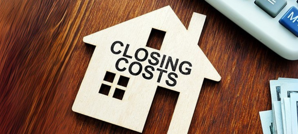 “Closing Costs” house cutout on desk with calculator and money visualizing real estate fees in Colorado