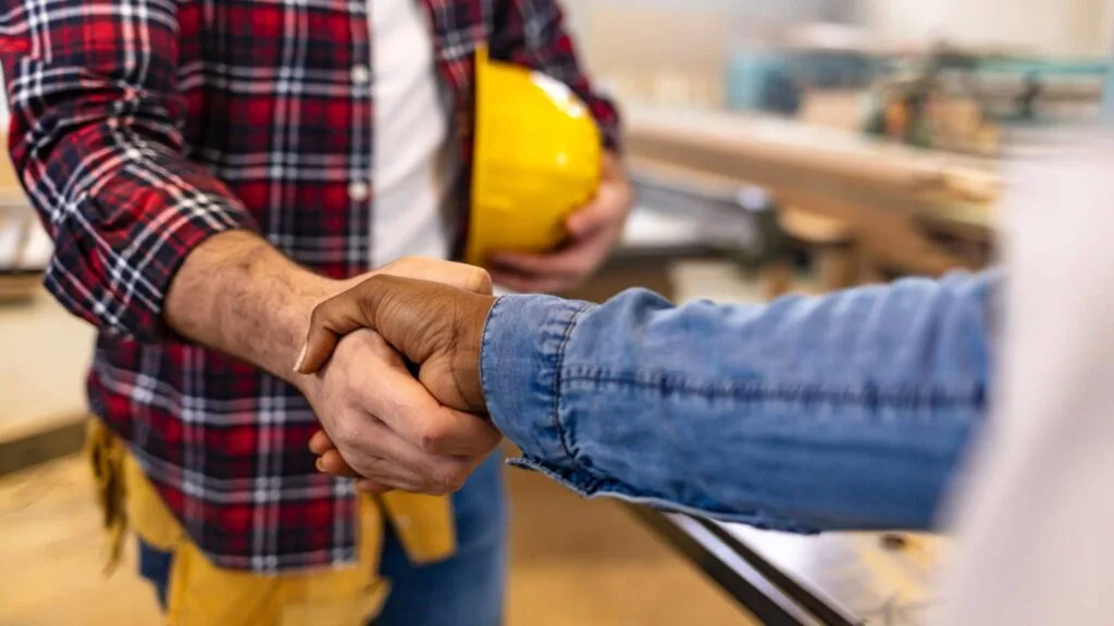 Two people shaking hands during a project consultation with Denver General Contractors.