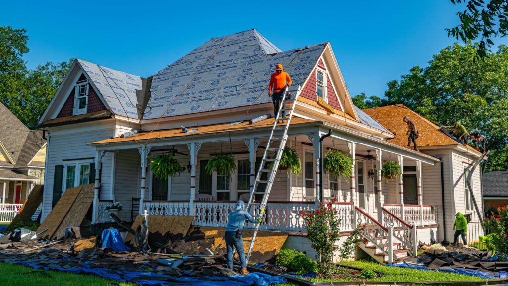 Home exterior renovation in progress with Denver General Contractors working on roofing and siding.