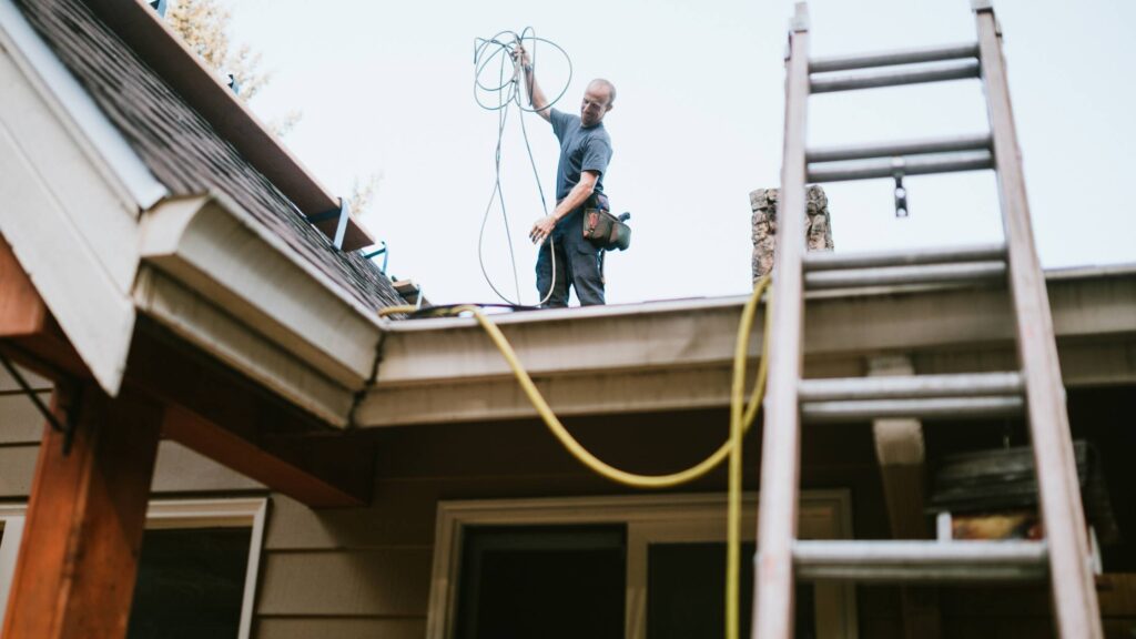 Contractor installing exterior lighting or wiring on a home as part of a Denver General Contractors project.
