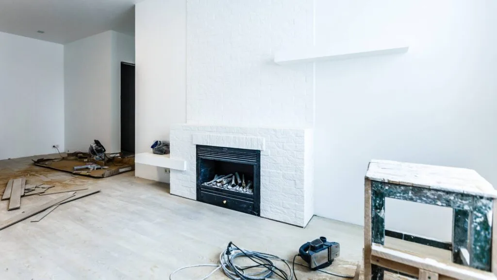 Living room under construction during a home remodeling Denver Colorado project, with drywall installation and fireplace updates in progress.