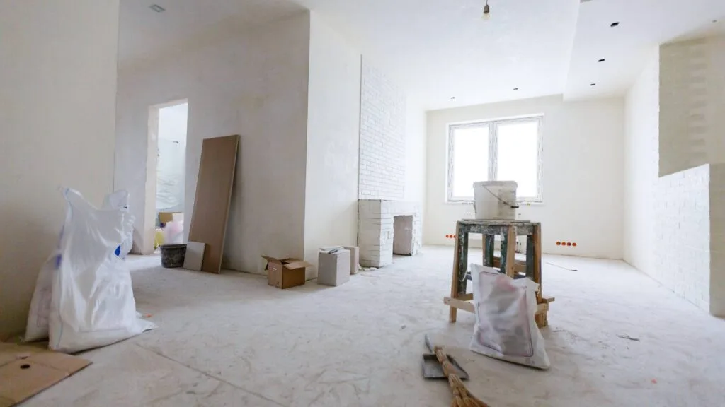 Interior space under construction during a home renovation Denver project, with unfinished walls and protective coverings on the floor.