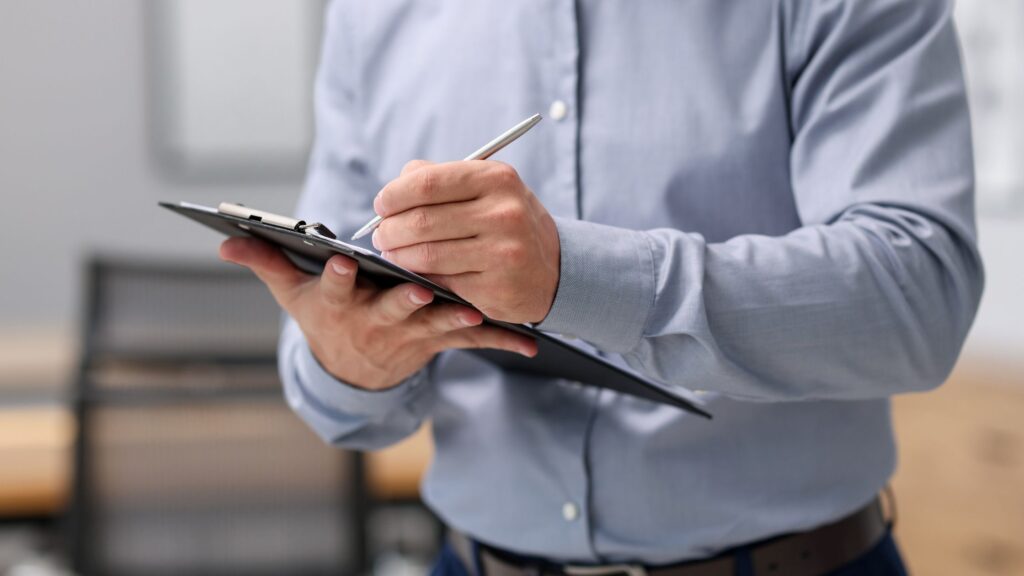 Inspector taking notes on a clipboard identifying home inspection red flags