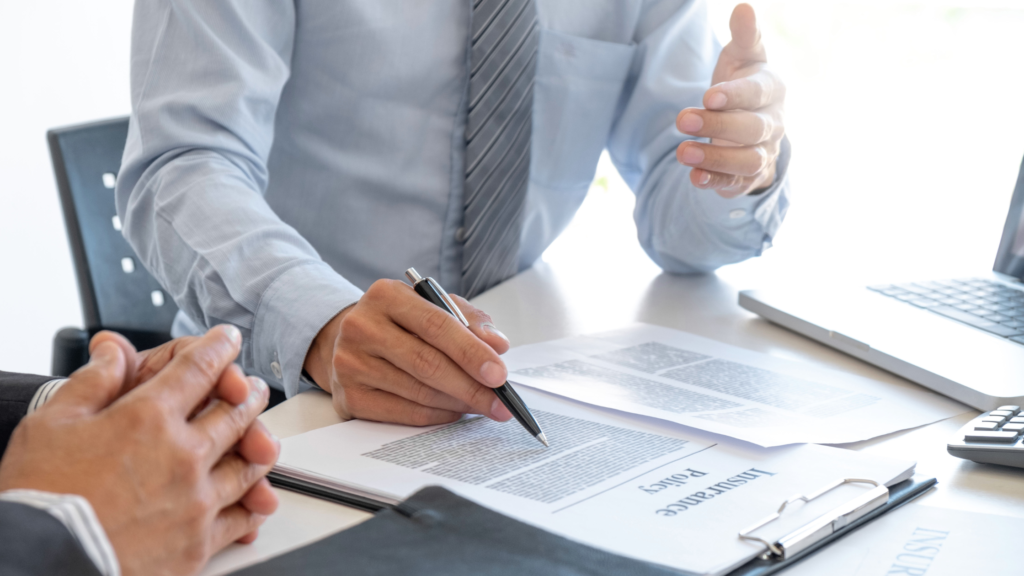 Buyer reviewing and signing title insurance Colorado paperwork during a real estate closing meeting.